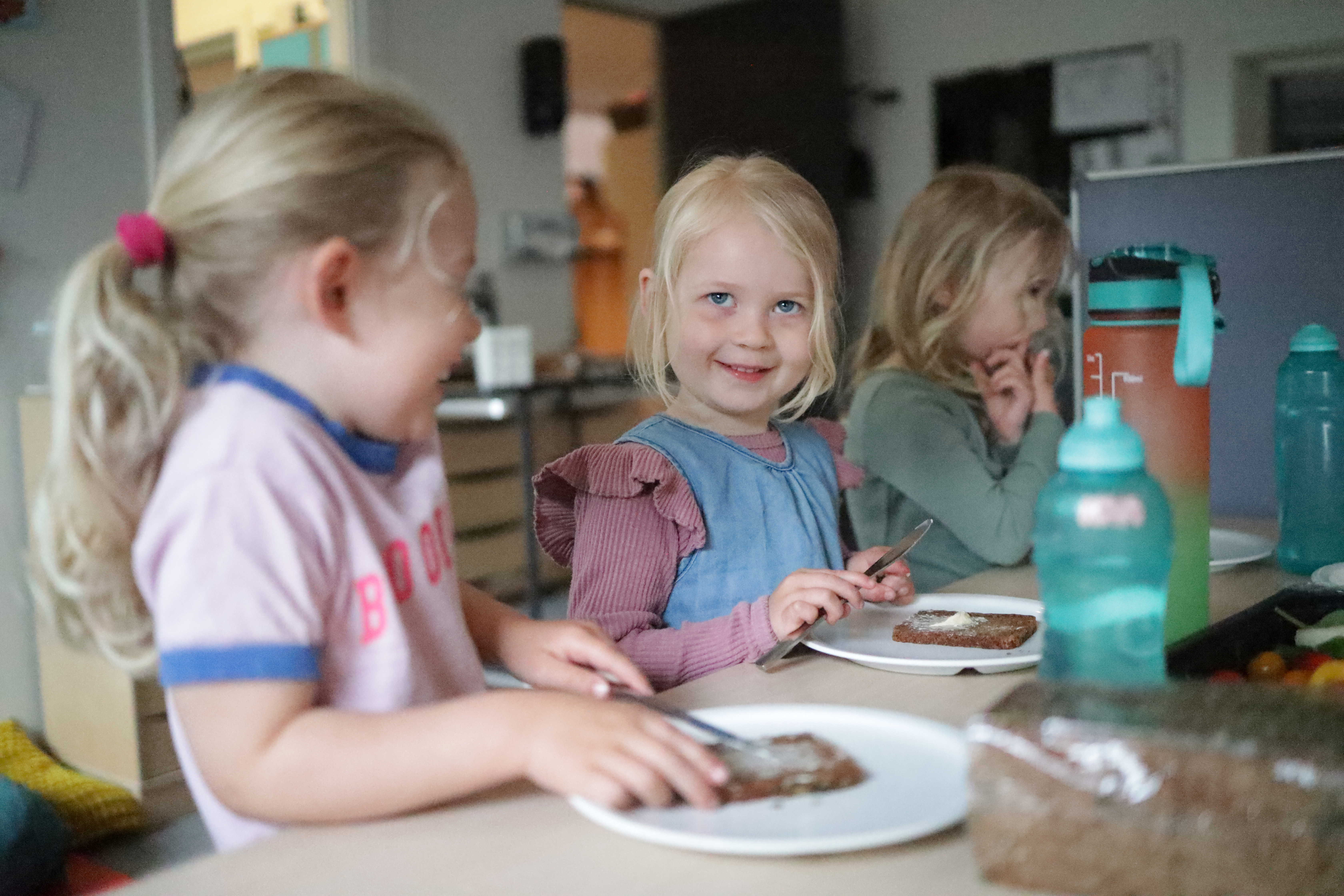 Tre piger, der smører rugbrød i Møllehuset